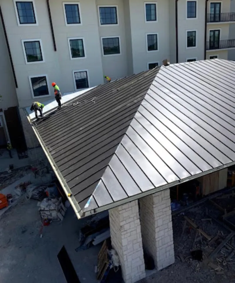 Crew installing standing seam metal roof panels on a commercial project in North Las Vegas